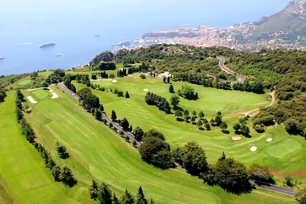 Fairways of the Monte-Carlo golf course at La Turbie from above, the principality and the sea far below