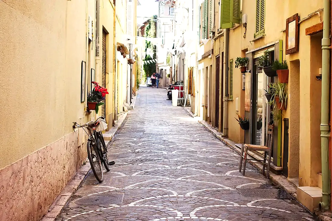 A cobbled lane in Old Antibes, a bicycle and a chair outside a doorway