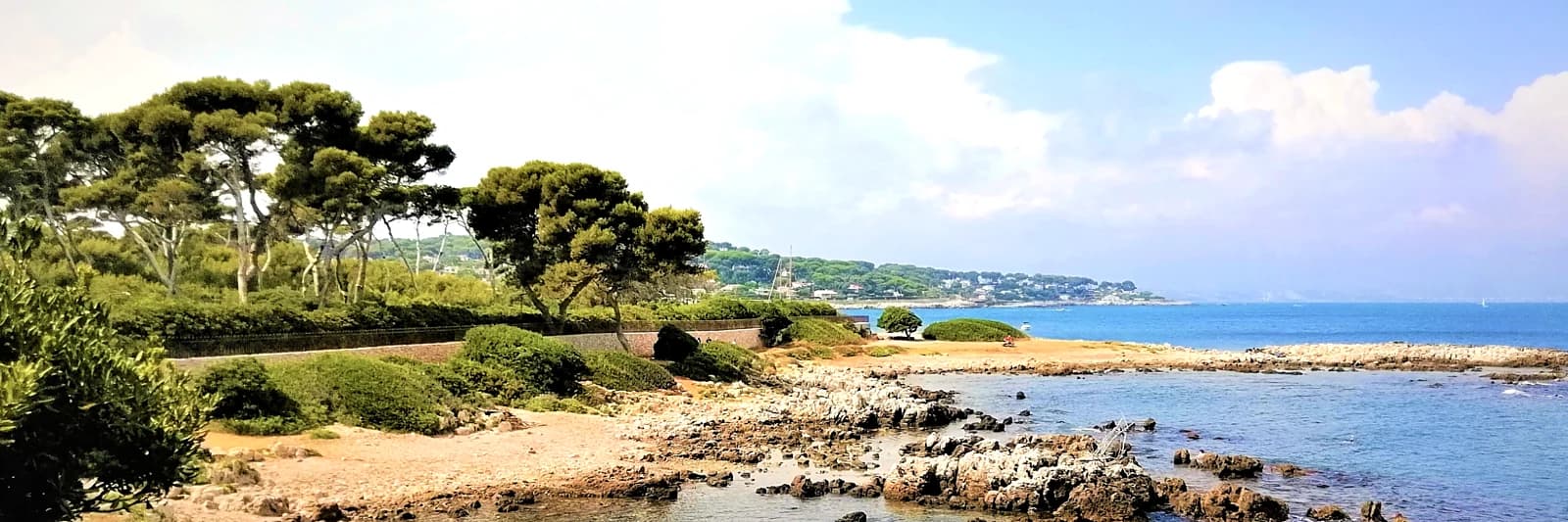 The wild coast of the Cap d’Antibes along the Sentier des Douaniers: umbrella pines, white rock and open sea