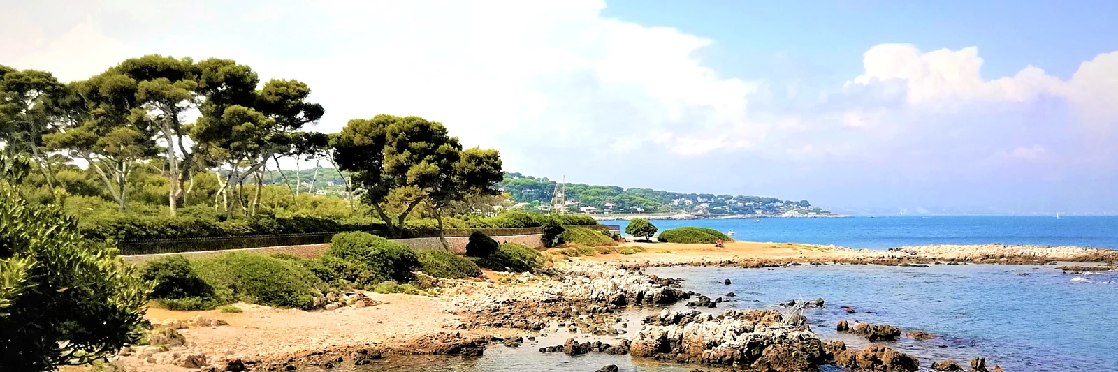 The wild coast of the Cap d’Antibes along the Sentier des Douaniers: umbrella pines, white rock and open sea