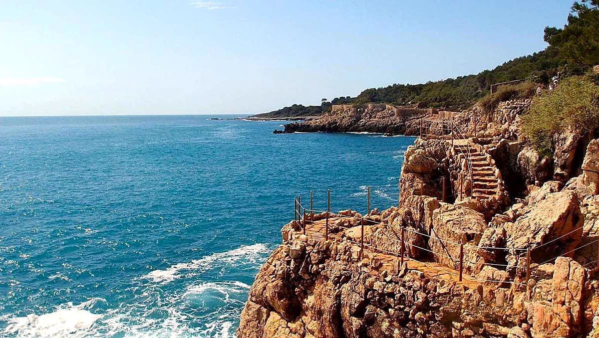 Steps and handrails on an exposed cliff section of the Cap d’Antibes coastal path