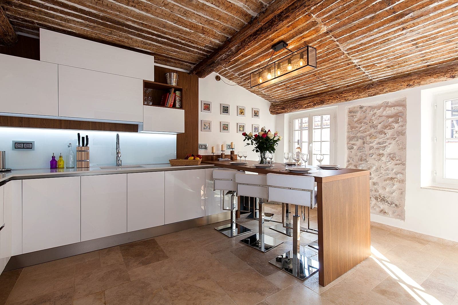 Old beams and exposed stone in the restored kitchen of Maison Baieta, old Antibes