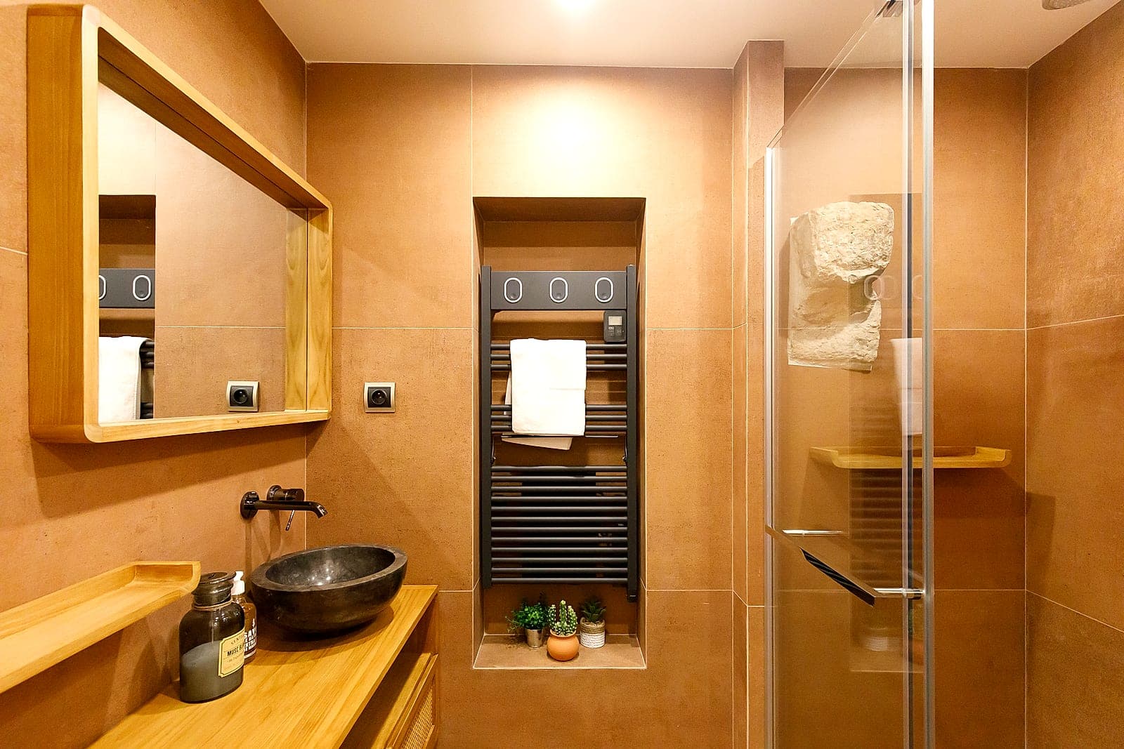 Black granite and teak bathroom against historic stonework, Maison VistaMar, old Antibes